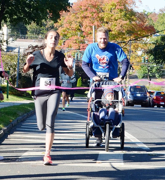 <p class="Picture">First place female runner Lily Janjigian of Woodland Drive finished with a time of 20 minutes and 59 seconds. She is followed closely by second-place male runner Chris Budden and his 2-year-old son Colin of Puritan Drive.&nbsp;</p>