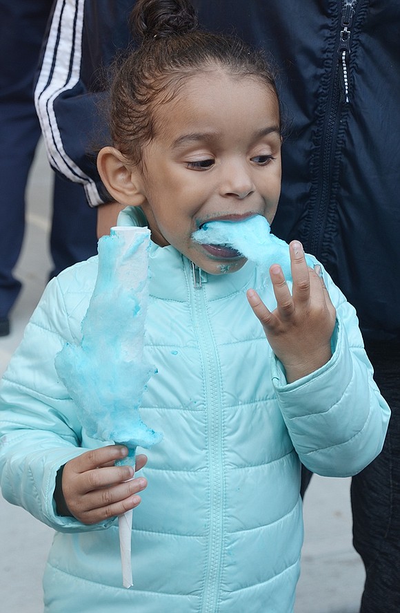 <p class="Picture">Daliyah Hall, 3, of Haseco Avenue eats blue cotton candy matching the color of her jacket as she watches the parade go by.</p>