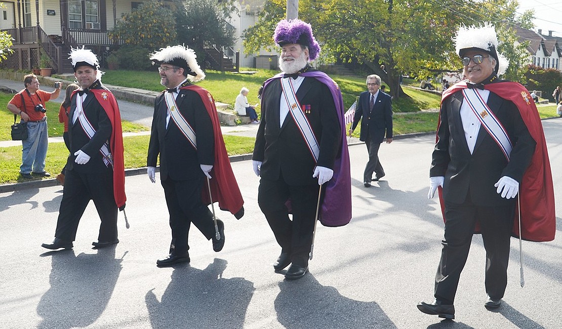<p class="Picture">Third Degree members of the Father John M. Grady Council of the Knights of Columbus sashay their way down Westchester Avenue in the parade.</p>