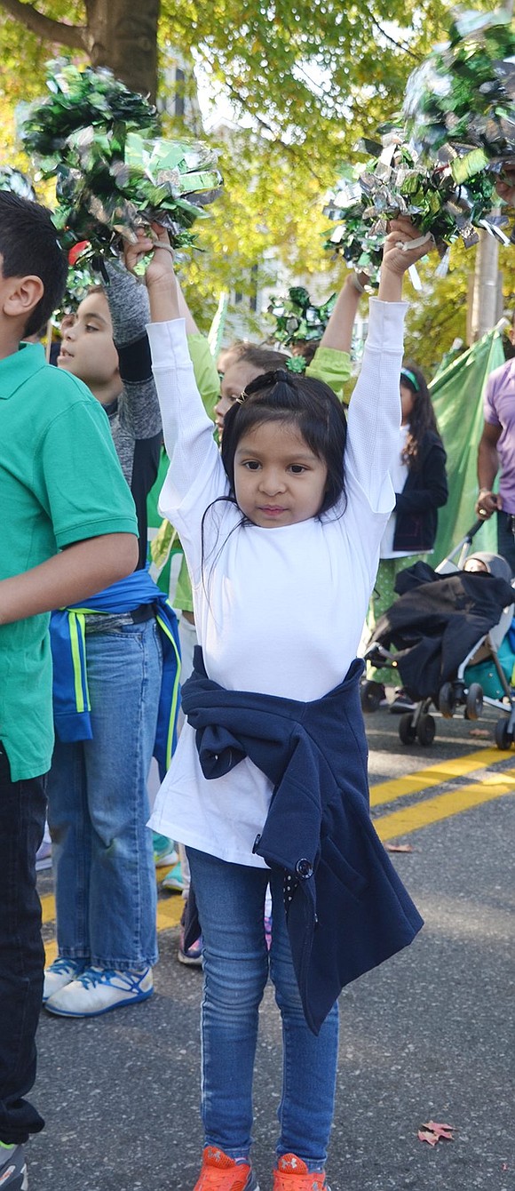 <p class="Picture">First grader Marcela Rosa, marching with the Edison School contingent, raises her pom poms high in the air.</p>