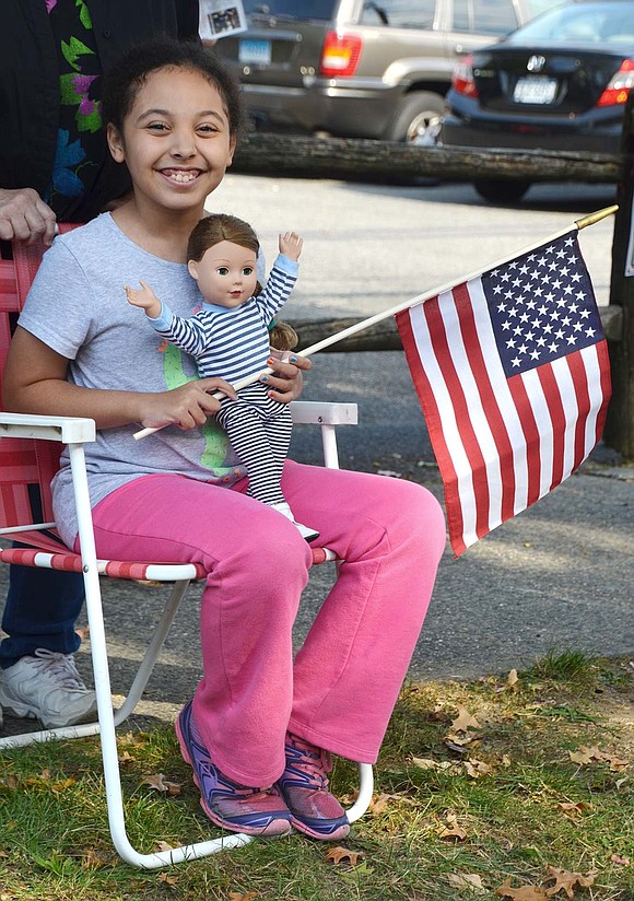 <p class="Picture">Jasmine Rivera, 9, of Upland Street watches the procession with her doll Alexandria.</p>