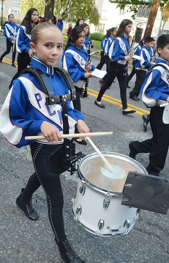 <p class="Picture">Elia Mateus, marching with the Port Chester Middle School 6<sup>th</sup> Grade Band, taps out the rhythm on her drum.</p>