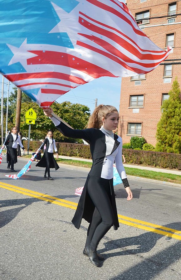 <p class="Picture">Freshman Megan Gleason, a member of the Port Chester High School Band color guard, proudly carries an unfurled red, white and blue flag that catches the wind as she passes by on Sunday, Oct. 16. It was postponed a week due to rain. Photo story by Richard Abel</p>