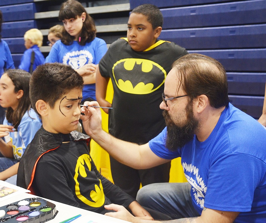 <span style="font-family: Arial;">To get into the superhero spirit, a boy gets Batman&rsquo;s mask painted on his face.&nbsp;</span>