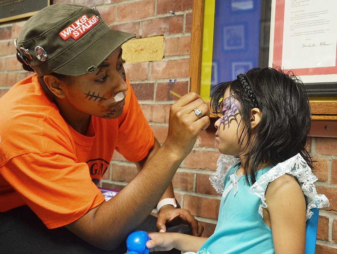 <p class="Picture">A princess gets her face painted with black and purple spider webs.&nbsp;</p>