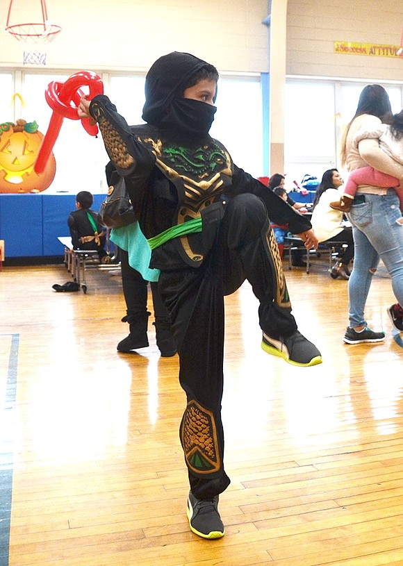 <p class="Picture">First grader Kevin Borcues channels his inner Reptile from Mortal Kombat and strikes a pose before he slashes his invisible adversary with his red balloon sword.&nbsp;</p>