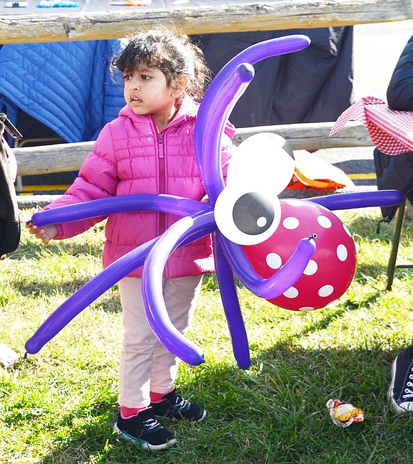 <p class="Picture">A little girl holds onto her purple and red octopus balloon animal.&nbsp;</p>