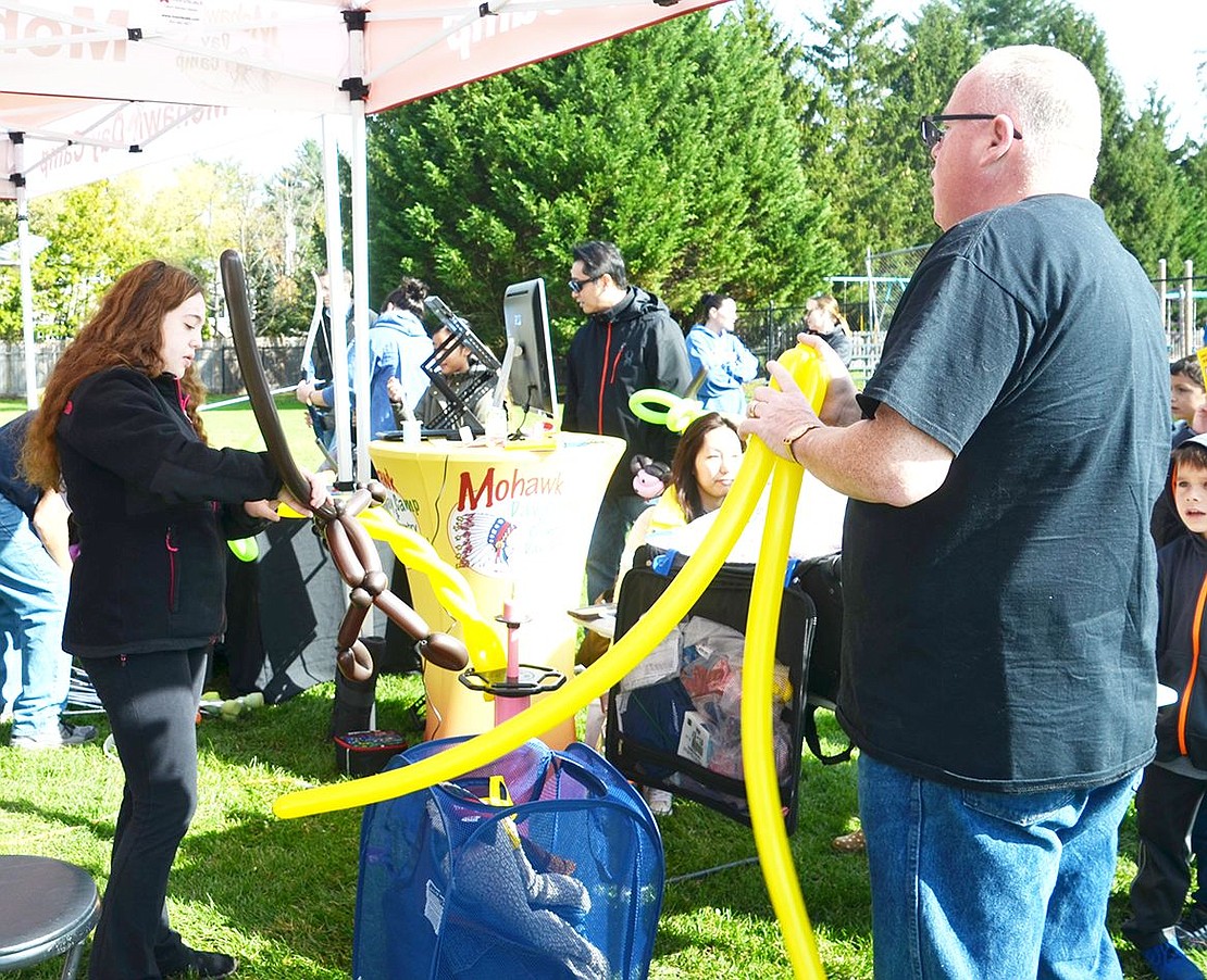 <p class="Picture">Mohawk Day Camp and Country Day School workers Daniella and Steven Harris are hard at work making balloon animals for a line of kids. Both are working on crafting a monkey that is holding onto a palm tree.&nbsp;</p>