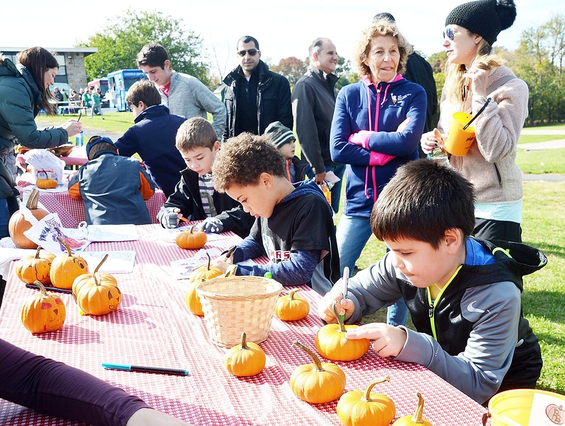 <p class="Picture">A couple of boys are hard at work decorating pumpkins and coloring Halloween-themed drawings.&nbsp;</p>