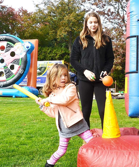 <p class="Picture"><span style="font-family: Arial;">Emmie Hodes of Mohegan Lane swings for the fences. The 5-year-old is a natural when it comes to baseball and managed to hit two targets on the blow-up game: a single and an out&nbsp;during Blind Brook PTA&rsquo;s Fall Fest behind Ridge Street School on Saturday, Oct. 29.&nbsp;</span></p>