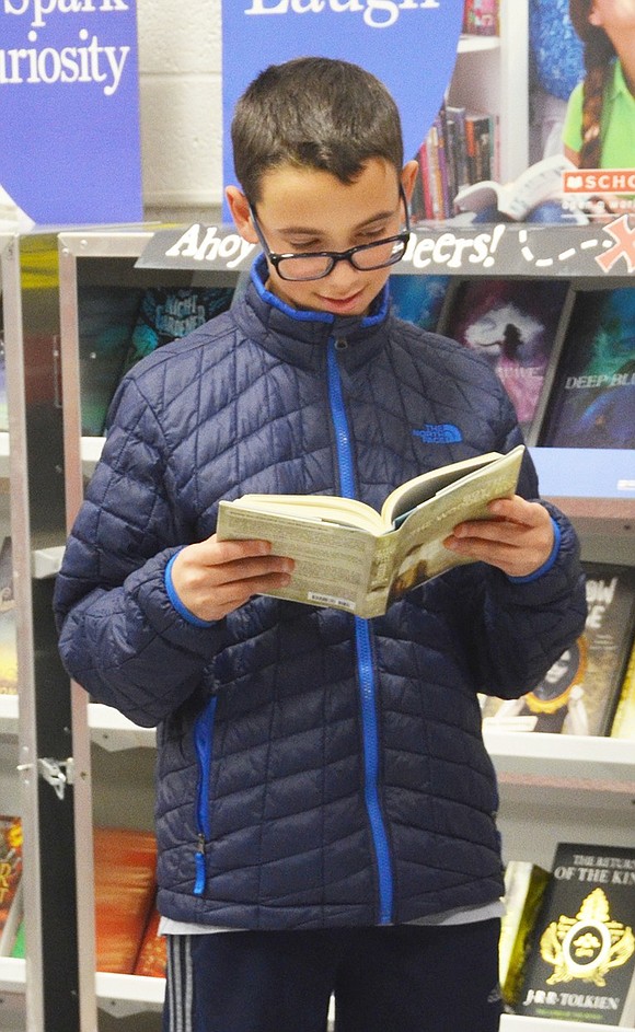 <span style="font-family: Arial;">Josh Rosenblut, a 7<sup>th</sup> grader, looks over a book before he decides whether or not he wants to buy it.&nbsp;</span>