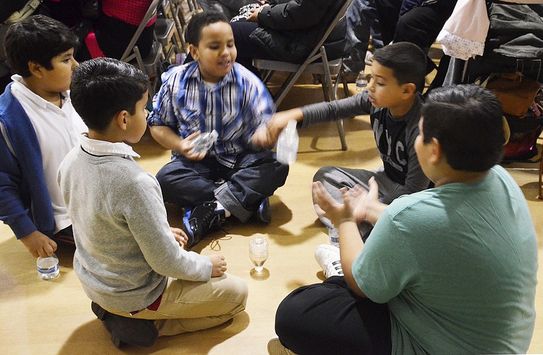 <p class="Picture">Many of the boys in the audience practiced their water bottle flipping skills in front of the stage or off to the side of the gymnasium while the performances were underway. The goal was to flip their water bottles and have them land either on the cap or back on the bottom.&nbsp;</p>