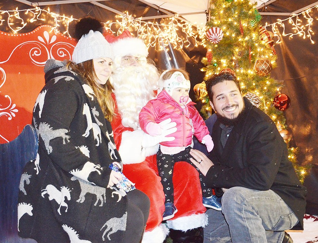 <p class="Picture"><span style="font-family: Arial;">The Gasparino family of Park Avenue poses with Santa Claus. This was one-year-old Abigail&rsquo;s first time meeting the jolly man in red and her parents Bridget and Rich couldn&rsquo;t have been happier with how well she behaved&nbsp;during Winterfest in Pine Ridge Park. The festivities took place during the night of Friday, Dec. 2.&nbsp;</span></p> <p class="Byline">Photo Story By Casey Watts</p>