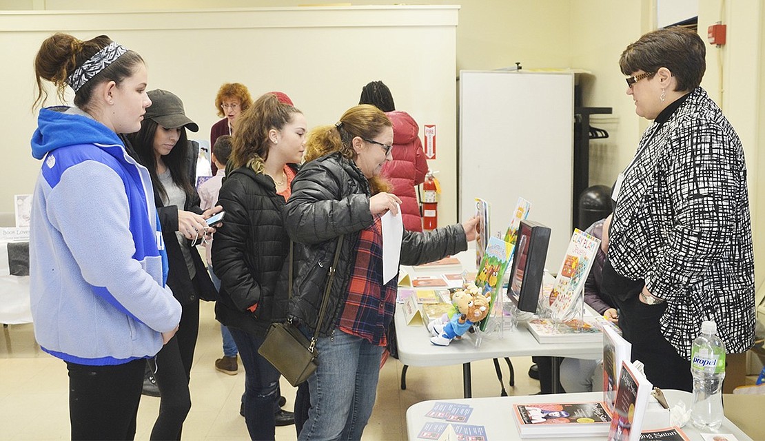 <p class="Picture">A group of women look at Port Chester author Terry Taylor&rsquo;s books and illustrations.&nbsp;</p>