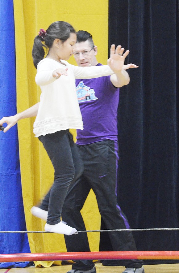 <p class="Picture">Charlotte Zelin tests her balance on a tightrope. She is aided by Doug Young, the owner of Circus Kid Productions.&nbsp;</p>