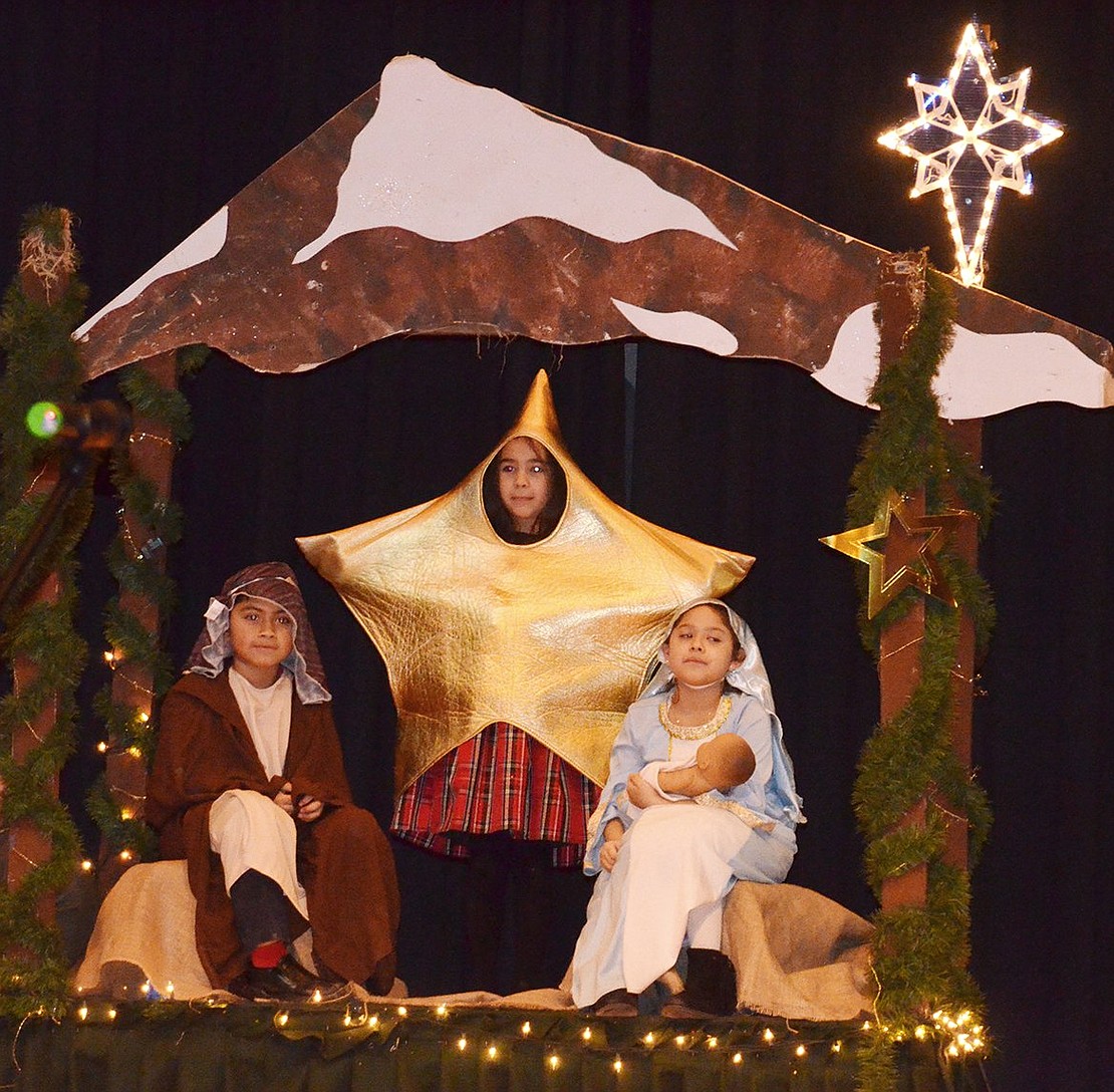 <p class="Picture">Mary, Joseph, Baby Jesus and the Star of Bethlehem in a manger, played by second graders Alessandria Rasile, Daniel DeLeon and Alyssa Gioffre Lopez.</p>