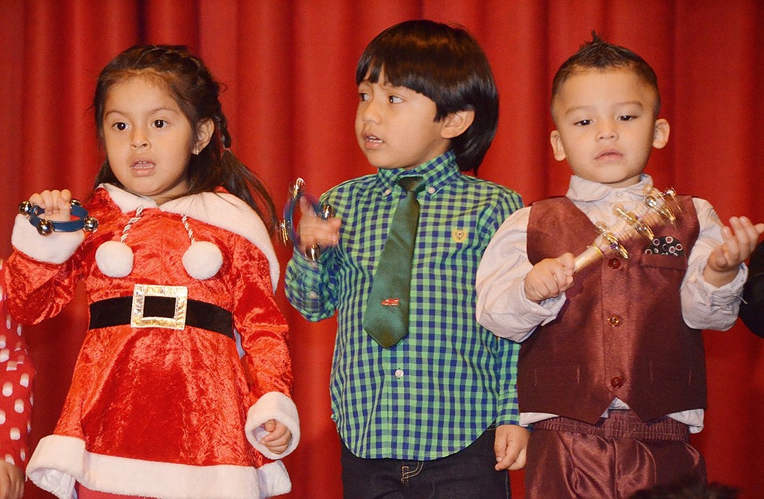 <span style="font-family: Arial;">From left, Mariana Tenecela, Jesus Ayala and Joshua Pasasin, all in Pre-K 3, sing and play &ldquo;Jingle Bells.&rdquo;</span>