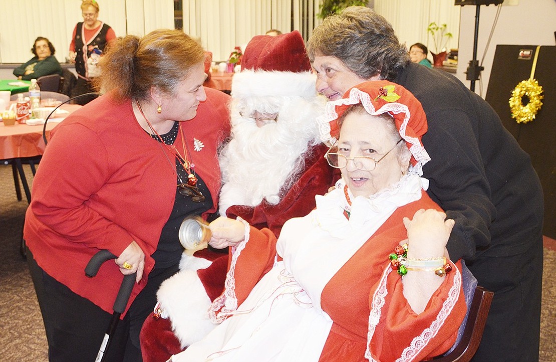 <p class="Picture">Susan Sabato and Connie Catalano take a picture with Santa and Mrs. Claus.</p>