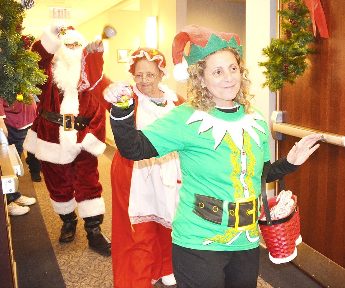 <p class="Picture">Diane Hernandez as an elf, Rosalie Luzzi as Mrs. Claus and Jorge Pizarro, the senior center bus driver, as Santa make their way into the party room to delight guests.</p>