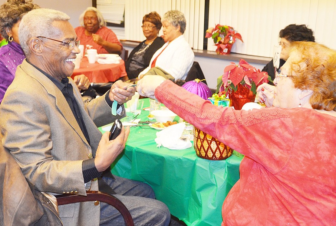 <p class="Picture">JoAnn Amico circulates throughout the room selling raffle tickets, here making a transaction with Hubert Pratt.</p>