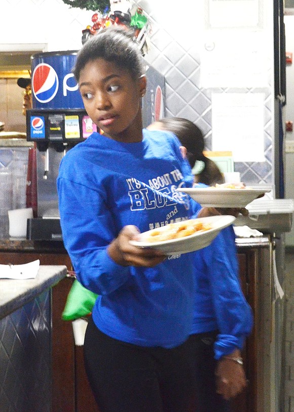 <p class="Picture">Ninth grader Naomi Ash dodges around the hustle and bustle of people to serve those sitting at table six.&nbsp;</p>