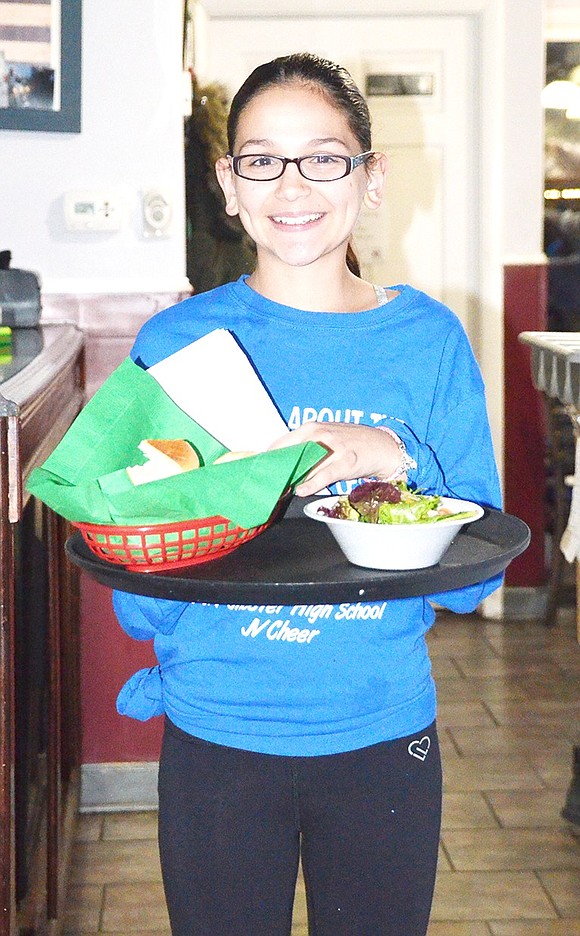 <p class="Picture">Ninth grader Theresa Di Leo poses with a tray of food before making her way to the upstairs sitting area. Each meal consisted of soda, bread, a salad and either a bowl of penne marinara or penne ala vodka.&nbsp;</p>