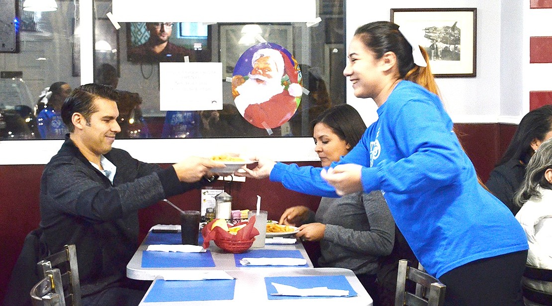 <p class="Picture"><span style="font-family: Arial;">Service with a smile: 11<sup>th</sup> grader Adriana Mendez hands a restaurant patron a bowl of pasta.&nbsp;Port Chester High School&rsquo;s Junior Varsity Cheer Squad took over Cousin Frankie&rsquo;s USA Grill at 112 Willett Ave. on Wednesday, Dec. 28 to help them raise the $1,400 each member needed by Wednesday, Jan. 4 to attend Nationals in Florida. In total, the group raised $1,395 from the $15 ticket fee. From that amount, the girls took $930 for their personal accounts.&nbsp;</span></p> <p class="Picture"><span style="font-family: Arial;"></span></p>