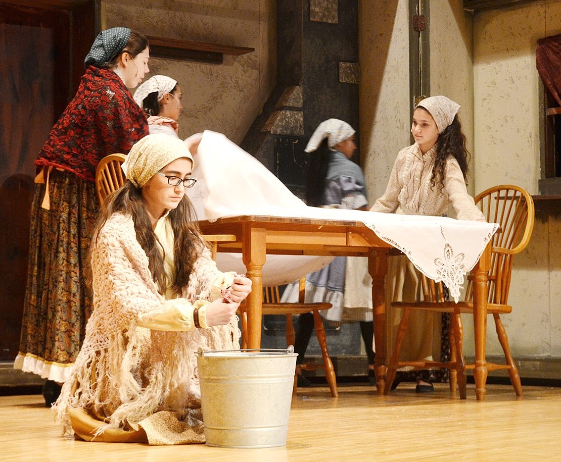 <p class="Picture">Spending the Sabbath with family. Mother and daughters set the table for dinner while the eldest daughter Tzeitel, played by Kate Kitchin, washes the floor.</p>