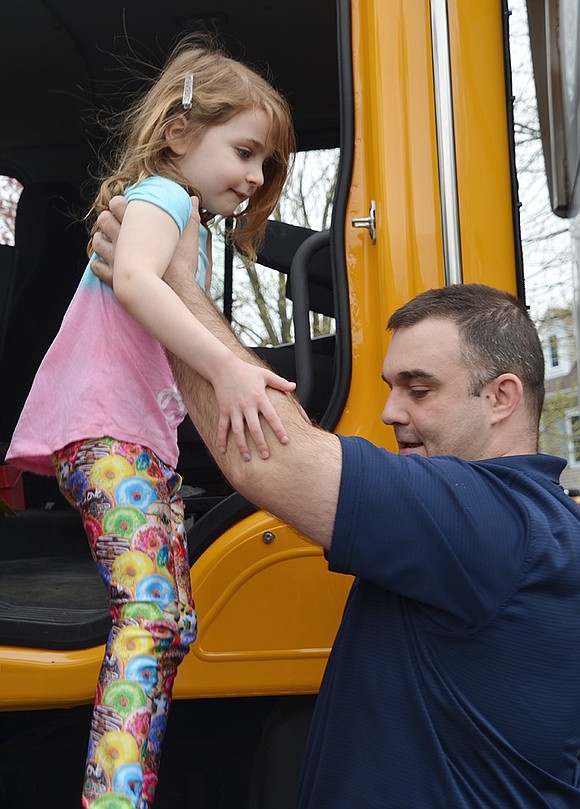 Rye Brook Superintendent of Public Works Michal Nowak lifts 5-year-old Blake Lerner, a resident of BelleFair but not a Bright Horizons student, out of one of the village’s plow trucks. She is the granddaughter of Ed Beane, Rye Brook’s village attorney.