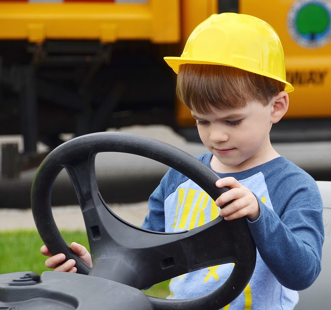 Four-year-old Nicholas Gerosa intently takes the wheel of the Sand Pro which grooms the village’s baseball fields.