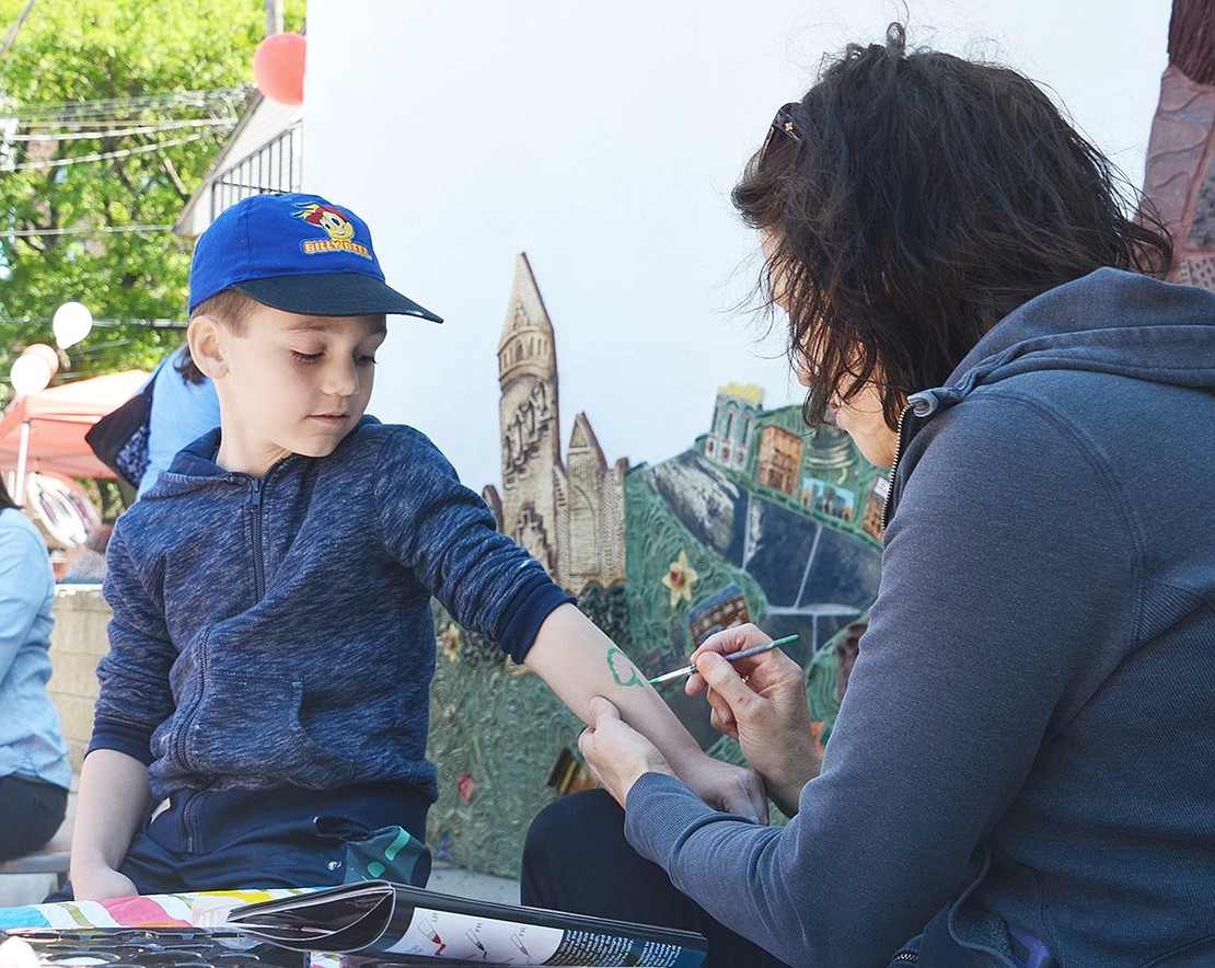 Brachiosaurus-lover and Rye resident Connor Oehmer, 6, is excited to get one of his favorite dinosaurs painted on his arm.