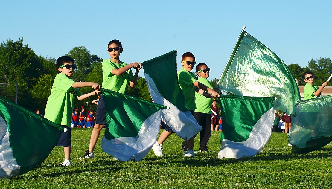 Thomas A. Edison Elementary School boys wave flags during their performance on the field. 