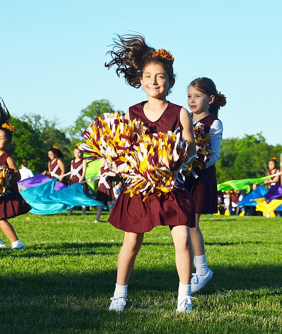 King Street School second grader Marisa Rachiele is nothing but smiles throughout her school’s pom-pom routine, even with the sun blinding her.