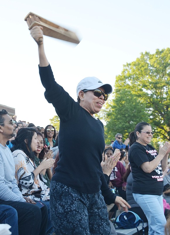 Make some noise! A mother is more than happy to stand up and swing her noisemaker in the air to support Port Chester musicians. 