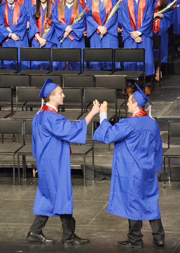 Graduations have a tendency to be long, so there’s no shame in being hungry! David Levy and Justin Levine remedy their growling stomachs by pulling out burgers and eating them as they walk to their seats. 