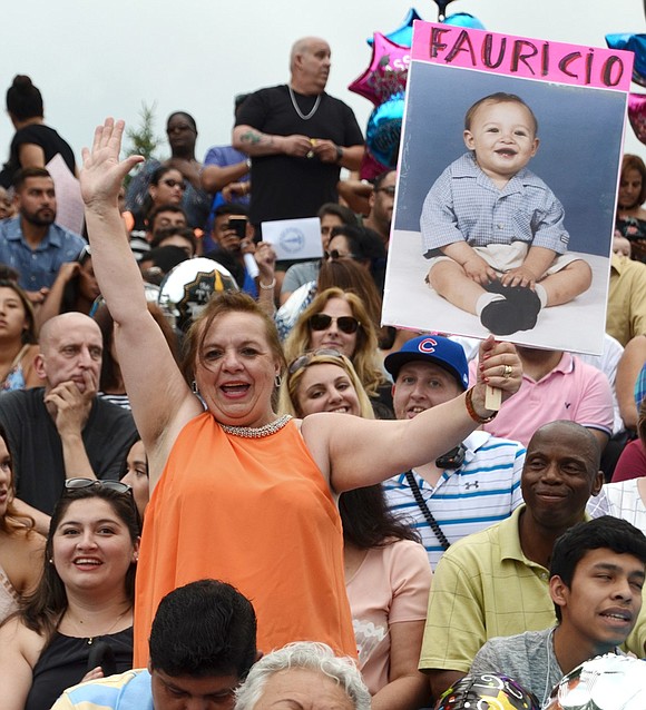 A proud mother holds up a baby picture of her graduating son, Fauricio Ibanez, in the stands at Ryan Stadium.