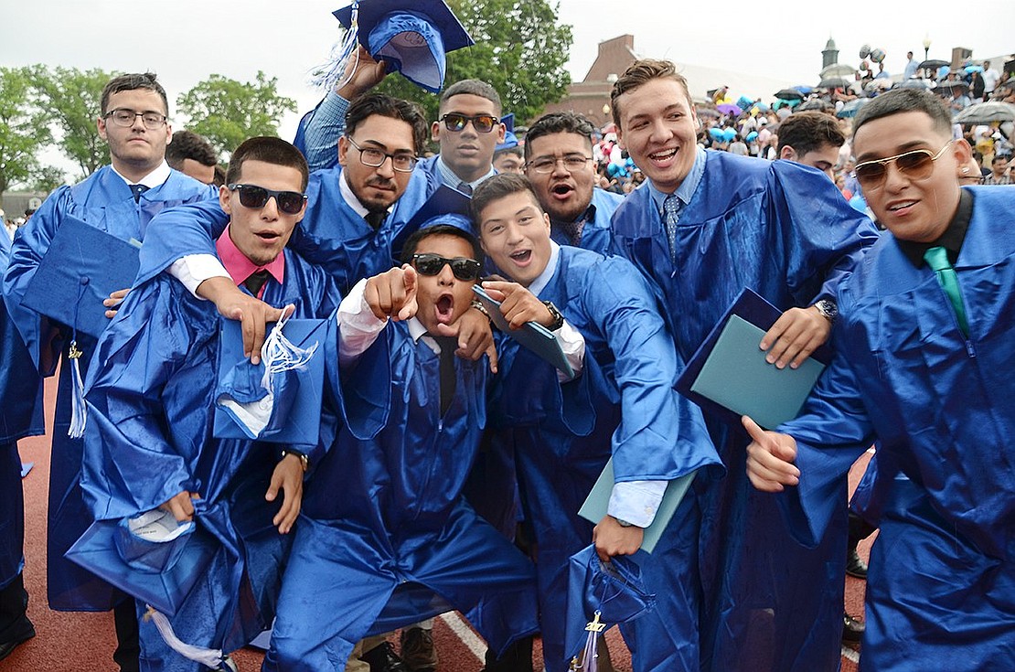 Merlin Gonzalez (center with mouth open) gathers his friends for a group shot as they walk off the field.