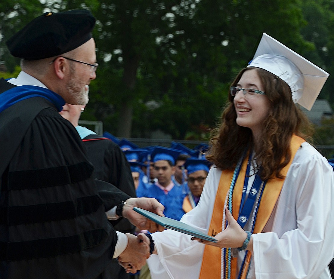 Salutatorian Anita Karas receives her diploma from Principal Dr. Mitchell Combs.