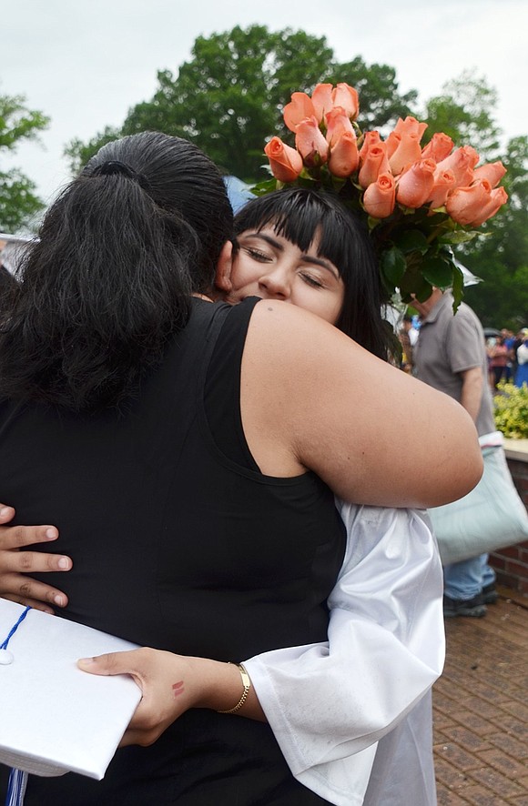 Graduate Paola Perez hugs her mom, Marcela, in the flag plaza following commencement.