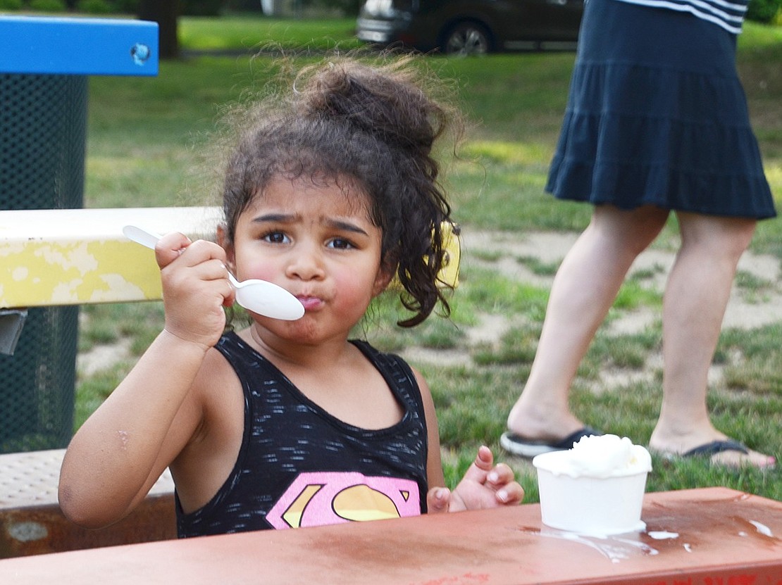 Three-year-old Amelia Sykes of Elm Hill Drive takes a huge bite of her frozen vanilla treat.