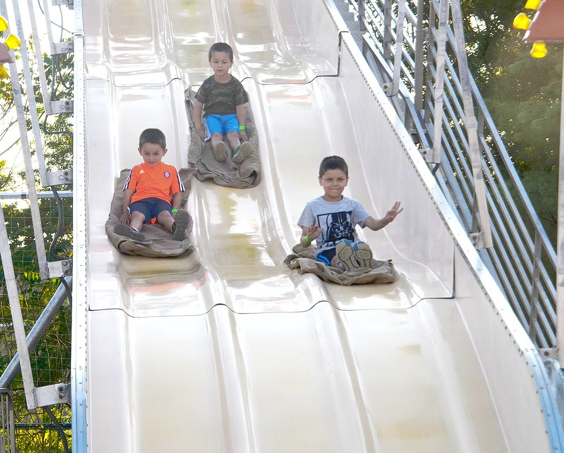 A race between friends; 5-year-old Christopher Povella (left) secured second place as his friend Luke Doherty, 5, (right) sped past the competition on the giant slide. Seven-year-old James Doherty came in third place; but they all were winners in the end. All the boys are from Rye Brook.