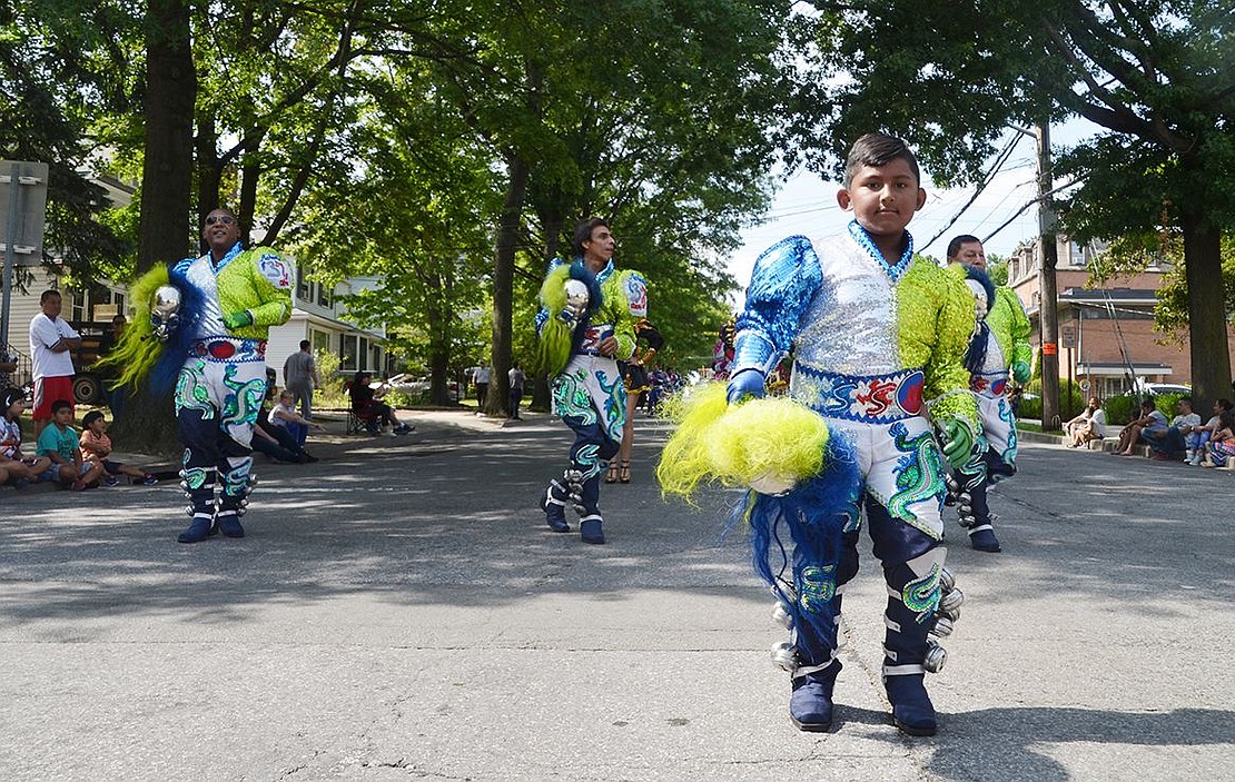 With bells attached to his ankles, 10-year-old Raney Nelson III leads a group of stomping men from Fraternidad Folklorica Cultural Caporales Universitarios de San Simón out of Bloque, N.Y. 