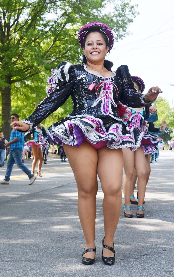 Noemy Ferreira of New York City, leading the San Simon dancers, is all smiles as she sashays down Westchester Avenue. 