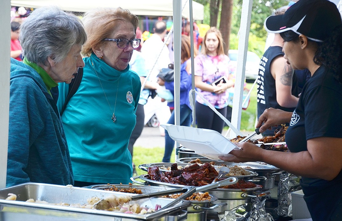 Magdelin Nunez dishes out food for sisters Pat Torres and Joy Lobdell of Puritan Drive from the Hubbard’s Cupboard Bistro booth. The restaurant, serving American and Spanish food, will be opening at the end of September in the Ernest Simons Building at 6 North Pearl St.