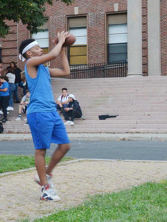 Port Chester High School junior Dashaun Epps passes the time by throwing a football to his friends. 