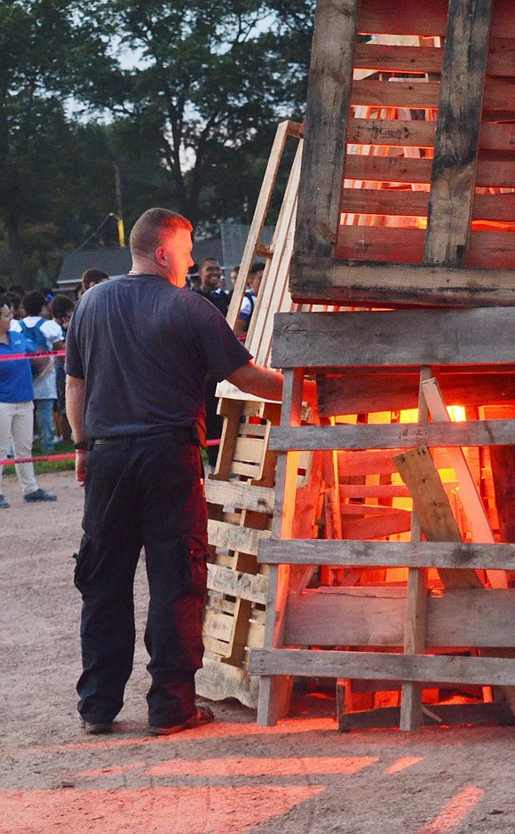 Port Chester High School’s Maintenance Coordinator Anthony Lude lights the wooden pallets with flares. 