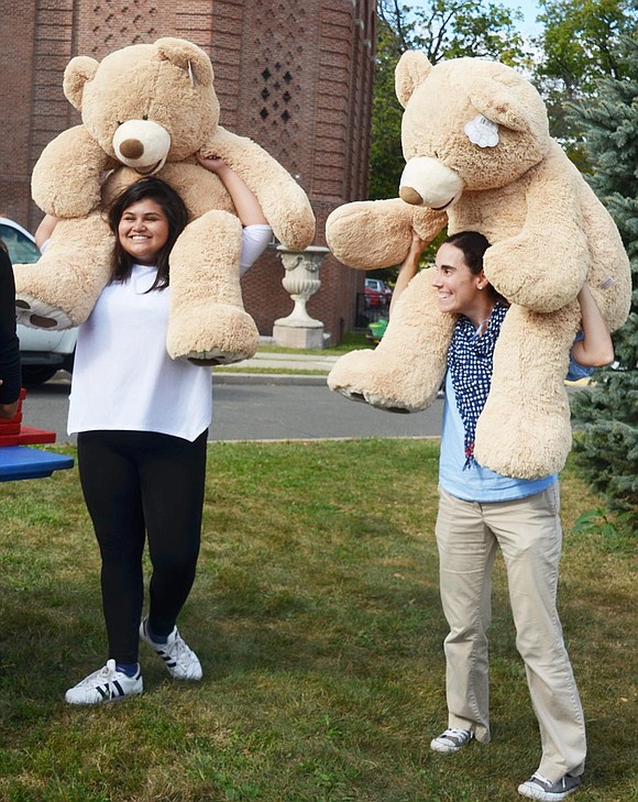 Sophomore Stephanie Villanueva and English as a second language teacher Sandra Savel show off the big bears students could win if they either made five basketball shots in a row or landed a ring around a specific water bottle top. 