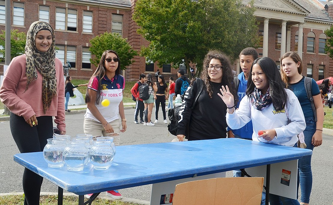 Sophomore Lindsey Co tries to win a monkey plushie by throwing a ping pong ball into fishbowls filled with water.