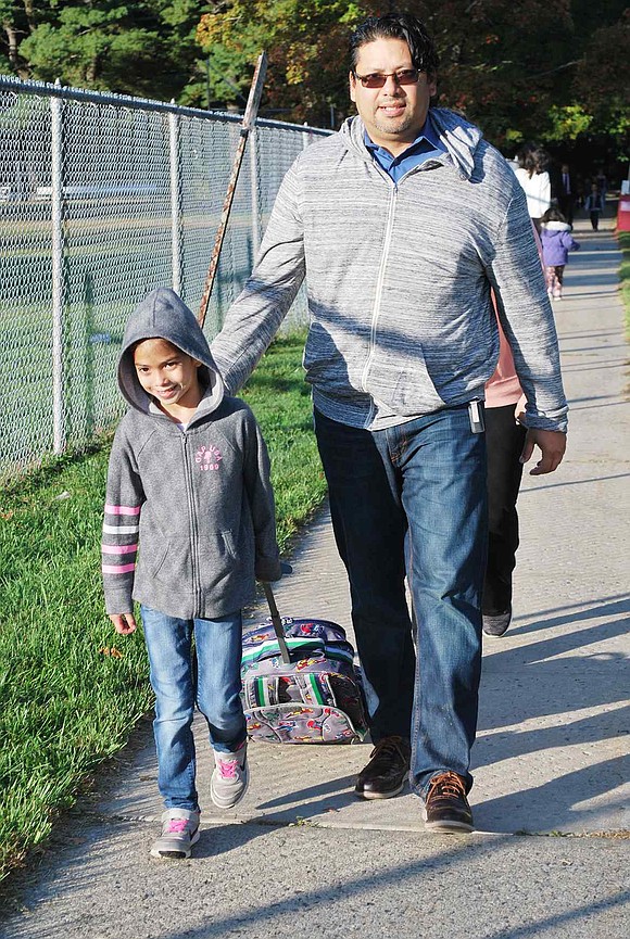 Mario Morales gives his daughter Micaela, a second grader, a hand as they near King Street School after walking from Glendale Place.