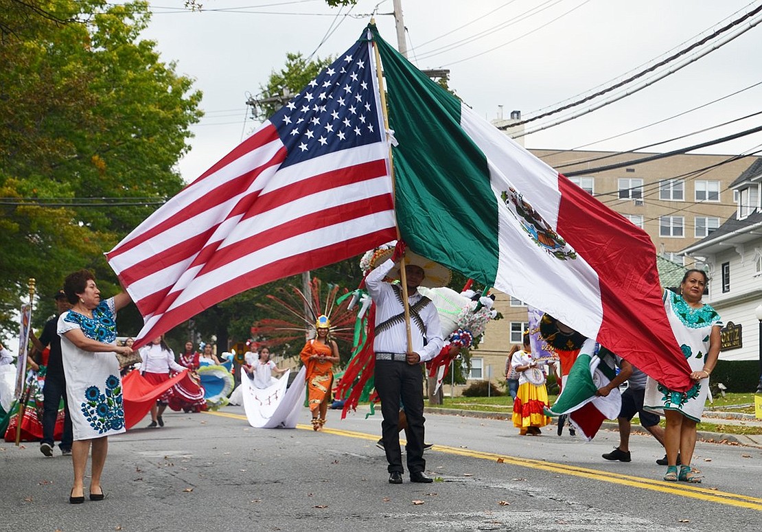 Members of Comitiva Guadelupana Port Chester display the American flag and the Mexican flag side-by-side. 